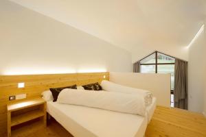 a bedroom with a white couch and a window at Vallesinella Hotel Restaurant Bar in Madonna di Campiglio