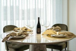 a white table with a bottle of wine and glasses at Luxurious Impressive Apartment - Balcony and Pool in Vila Nova de Gaia