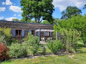 una casa de madera con un jardín delante de ella en Ferme des Poulardieres, en Crouy-sur-Cosson