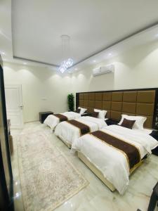 1 Schlafzimmer mit 4 Betten in einem Zimmer in der Unterkunft ڤيلا جوف in Aţ Ţuwayr