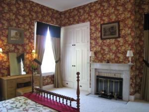 1 dormitorio con chimenea y 1 cama. en Allegheny Street Bed & Breakfast en Hollidaysburg