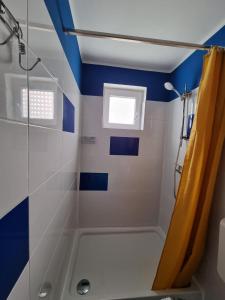 a blue and white bathroom with a shower at City Break Apartment in Zagreb