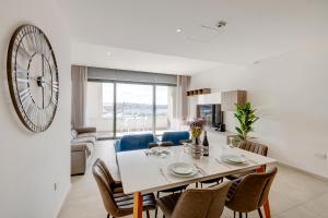 スリーマにあるDeluxe Apartment with Valletta and Harbour Viewsのダイニングルーム、リビングルーム(壁に大きな時計付)