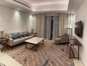 a living room with a couch and a table at Luxurious apartment at address residences in Fujairah