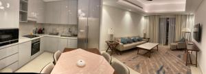 a kitchen and living room with a table and a couch at Luxurious apartment at address residences in Fujairah