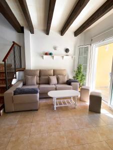 sala de estar con sofá y mesa en Chalet Villafranca Menorca con piscina privada, en Cala'n Bosch