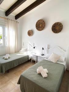 Un dormitorio con 2 camas y una mesa con en Chalet Villafranca Menorca con piscina privada, en Cala'n Bosch