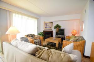 een woonkamer met een bank en stoelen en een televisie bij Crab Cove On The Bay 406 in Ocean City