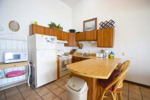 una cucina con tavolo in legno e frigorifero bianco di Crab Cove On The Bay 406 a Ocean City