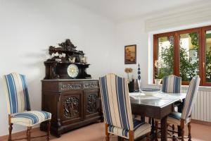 ein Esszimmer mit einem Tisch, Stühlen und einer Uhr in der Unterkunft Il Sogno in Sorrent
