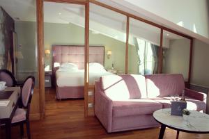 a living room with a bed and a couch at Hôtel de Sèze & Spa Bordeaux Centre in Bordeaux