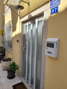 ein Schild an der Seite eines Gebäudes mit einem Fenster in der Unterkunft STUDIO PORTO in Korfu-Stadt