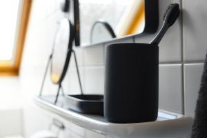 ビューズムにあるkutterbude Büsum - bude Iのバスルームの棚に黒い歯ブラシホルダー