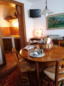 ein Esszimmer mit einem Holztisch und einer Küche in der Unterkunft Casa Perni in Buccheri
