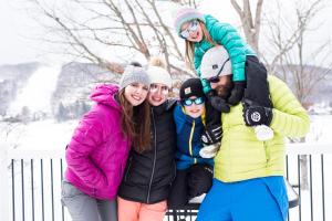 un grupo de personas posando para una foto en la nieve en The Lodges at Sunset Village en McHenry