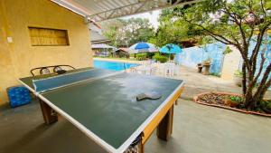 a ping pong table in front of a swimming pool at Recanto São José in Atibaia