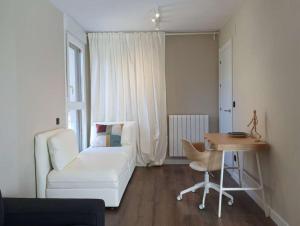 a living room with a white couch and a table at Apartamento Posets in Jaca