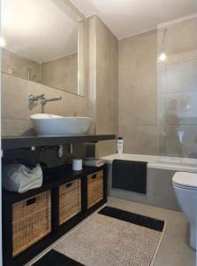 a bathroom with a sink and a tub and a toilet at Apartamento Posets in Jaca