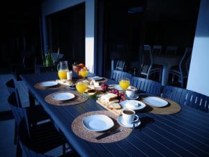 una mesa azul con comida y vasos de zumo de naranja en Mar & Serra, en Feteiras
