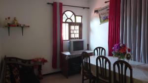 a dining room with a table with a computer and a window at Isurindi Villa in Midigama East