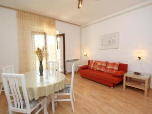 een woonkamer met een tafel en een rode bank bij Holiday Apartement Marija Supetar with private pool in Supetar