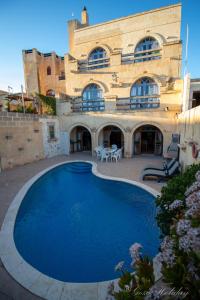 una grande piscina blu di fronte a un edificio di Lellux Qala a Qala