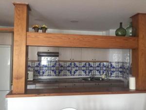 uma cozinha com azulejos azuis e brancos na parede em Casa Vacacional Torredano II em Nalda