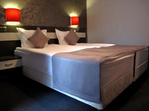 ein großes Bett in einem Zimmer mit zwei roten Lampen in der Unterkunft Gran Via in Burgas City