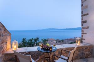 a table on a balcony with a view of the ocean at Pablito House in Monemvasia