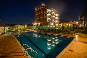a swimming pool in front of a building at night at Mlex Hotel in Kampala