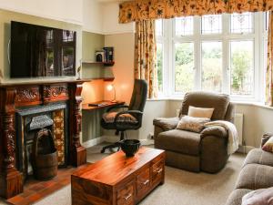 a living room with a fireplace and a chair at Sunningdale in Ludlow