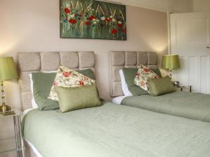 Dos camas una al lado de la otra en un dormitorio. en Sunningdale, en Ludlow