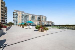 a large patio with tables and chairs and a building at Sea Colony Brandywine Garden in Bethany Beach