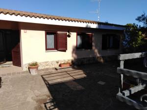 uma casa com um pátio em frente em Villa panoramica immersa nel verde em Porto Pino