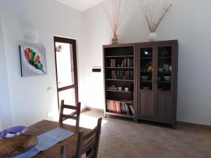 a dining room with a table and a book shelf at Villa panoramica immersa nel verde in Porto Pino
