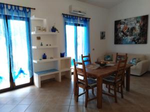 - un salon avec une table et des chaises en bois dans l'établissement Villa panoramica immersa nel verde, à Porto Pino