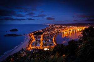 an aerial view of the city at night at Beaumont Apartments in Mount Maunganui