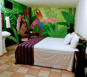 a bedroom with a bed with a tropical wallpaper at Hotel Esmeralda in Poza Rica de Hidalgo