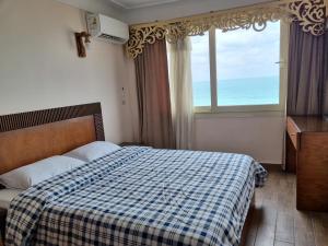 a bedroom with a bed and a window with the ocean at Sea point apartment in Alexandria
