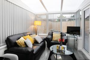 Una sala de estar con un sofá de cuero y una mesa. en Nottingham Top Serviced Home - Chayil Experts, en Nottingham