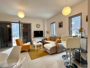 a living room with a couch and chairs and a tv at Lavender Bay Apartment C23 in Kotor