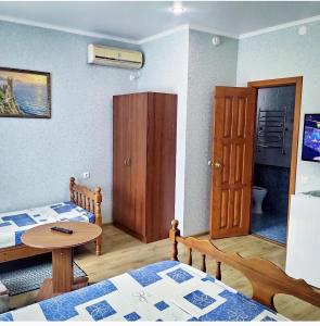 um pequeno quarto com duas camas e uma mesa em Guest house Chetyre podkovy em Gelendzhik