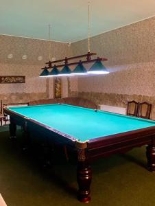 a pool table in a living room with at Golden Lion Hotel in Boryspilʼ