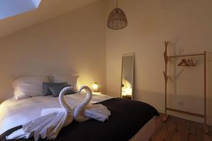 two white swans are sitting on a bed at La Belle Tourangelle#Rabelaisien Free parking in Tours