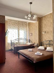a bedroom with two beds and a window at Golden Lion Hotel in Boryspilʼ