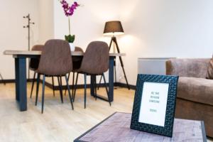 a living room with a table and chairs and a couch at LA CAMBUSE TOPDESTINATION-BOURG - Centre ville - Classé 3 étoiles in Bourg-en-Bresse