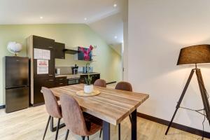 a kitchen and dining room with a wooden table and chairs at LA CAMBUSE TOPDESTINATION-BOURG - Centre ville - Classé 3 étoiles in Bourg-en-Bresse