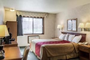 Habitación de hotel con cama y escritorio con teléfono en Econo Lodge North en Sioux Falls