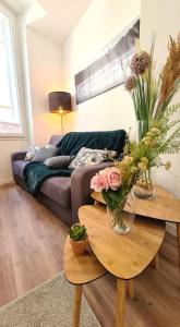a living room with a couch and a table with flowers at Bel appartement Type T3 climatisé in Marseille