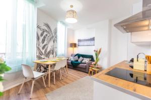 a kitchen and living room with a table and chairs at Bel appartement Type T3 climatisé in Marseille